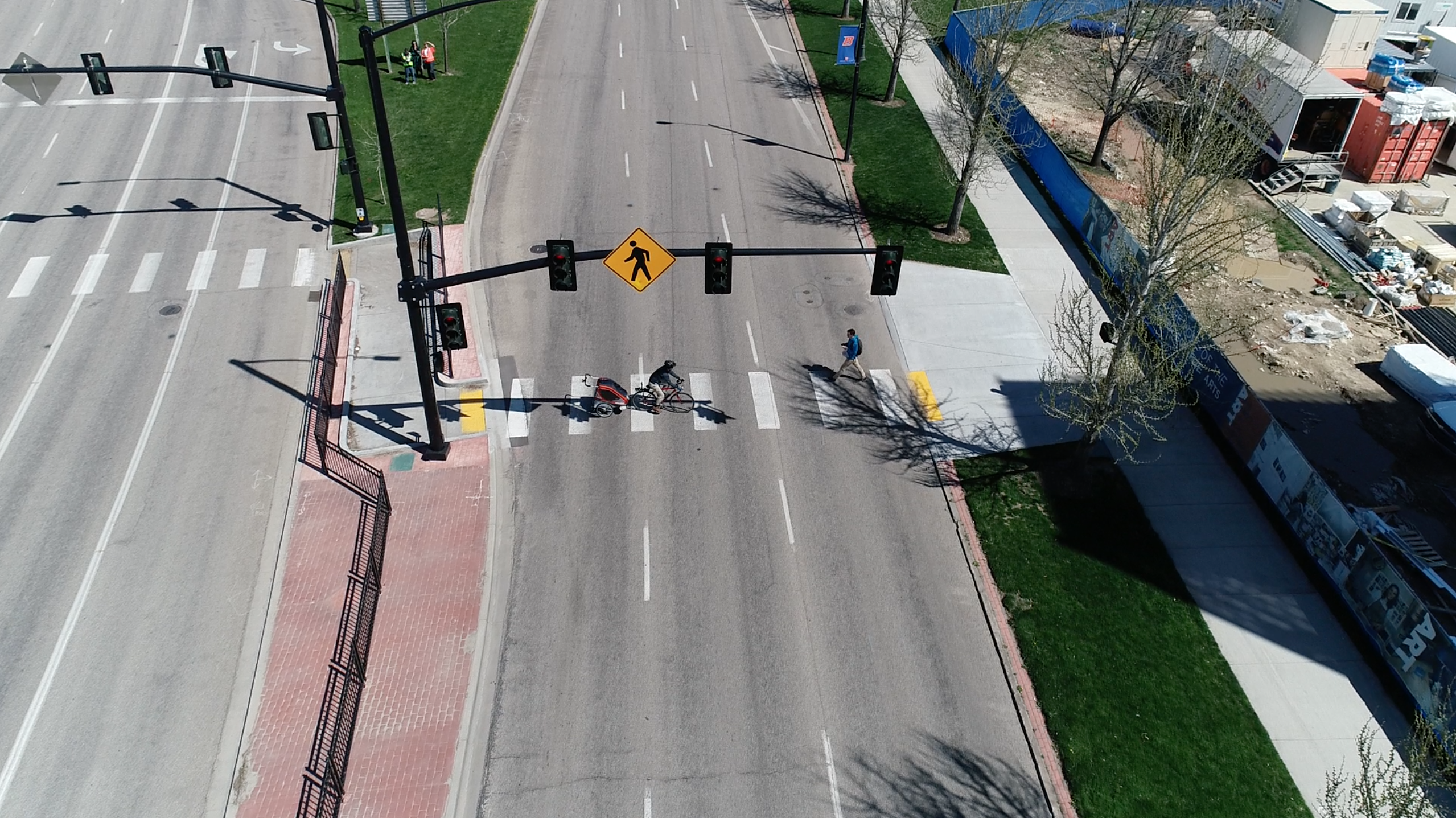 Pedestrian and bicyclist crossing a road at a z-pedestrian crossing.